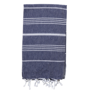 A folded navy blueTurkish towel with white stripes and fringes on the bottom